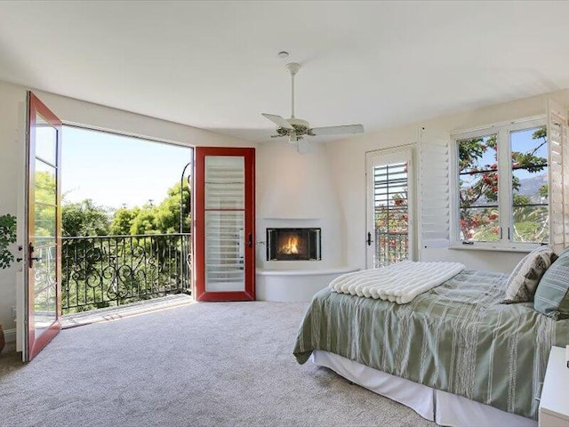 bedroom featuring a fireplace, carpet floors, and access to outside