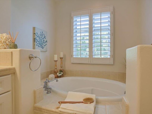 full bathroom with a bath, plenty of natural light, and vanity