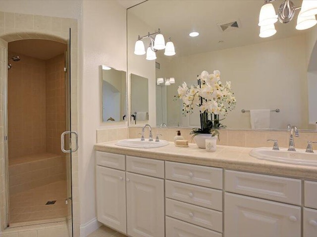 full bath with a shower stall, a chandelier, a sink, and visible vents
