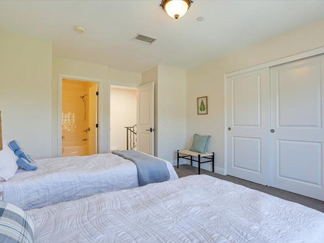 bedroom with ensuite bathroom, baseboards, visible vents, carpet, and a closet