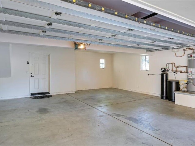 garage with baseboards, strapped water heater, and a garage door opener