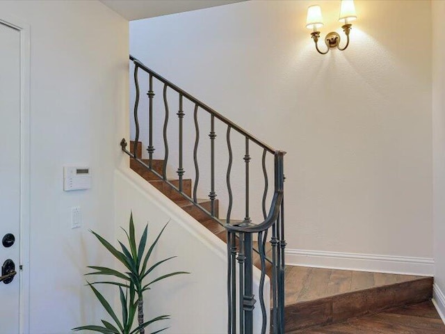 staircase with baseboards and wood finished floors