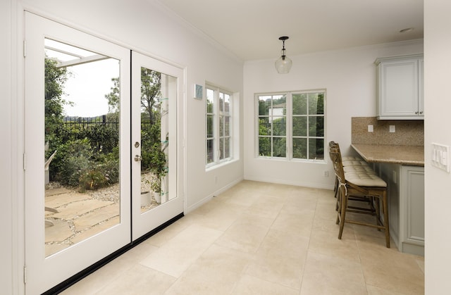 interior space featuring baseboards, light tile patterned floors, and crown molding