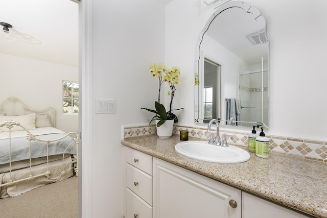 bathroom with decorative backsplash, a wealth of natural light, vanity, and a shower with shower door