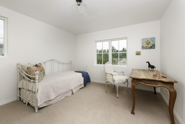 bedroom with light carpet and baseboards
