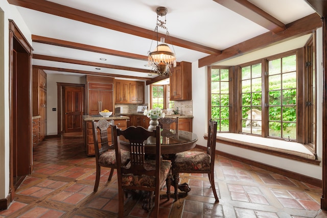 dining space with beamed ceiling, a chandelier, and baseboards