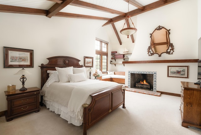 bedroom featuring light colored carpet, baseboards, a lit fireplace, and vaulted ceiling with beams