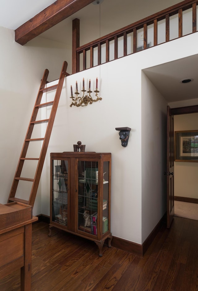 stairs with beamed ceiling, wood finished floors, and baseboards