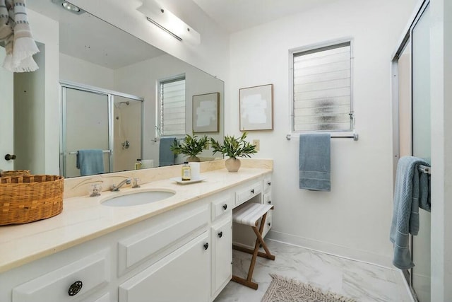 bathroom with marble finish floor, baseboards, vanity, and a stall shower
