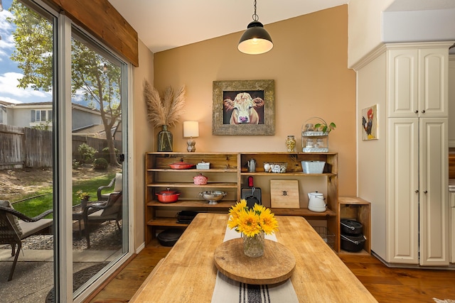 dining area featuring vaulted ceiling and wood finished floors
