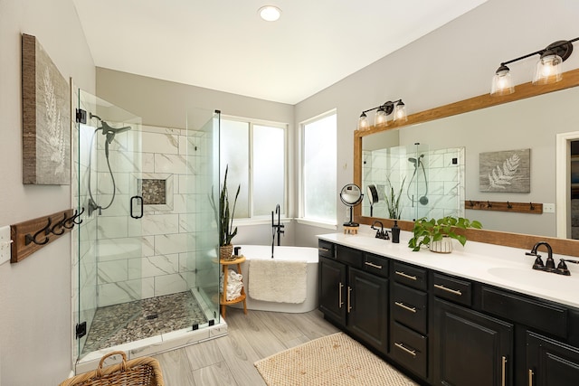 full bath with a freestanding tub, a shower stall, double vanity, and a sink