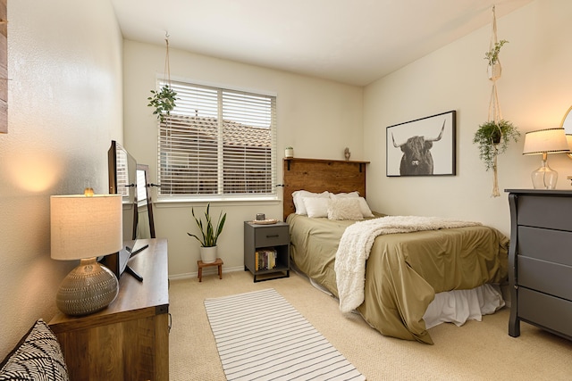 bedroom with baseboards and light colored carpet