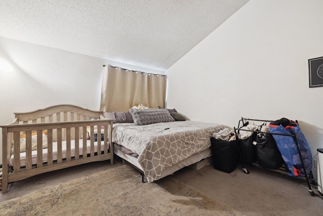 bedroom with lofted ceiling, a textured ceiling, and carpet