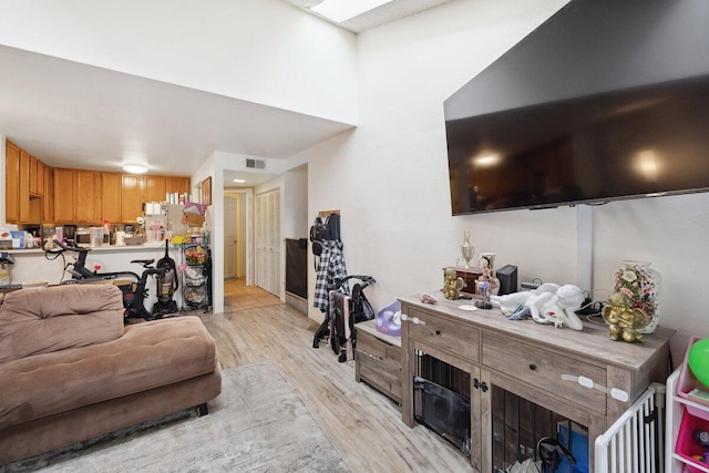 living room with light wood-style floors and visible vents