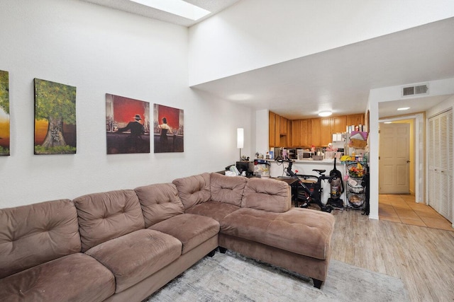 living area with visible vents and light wood finished floors