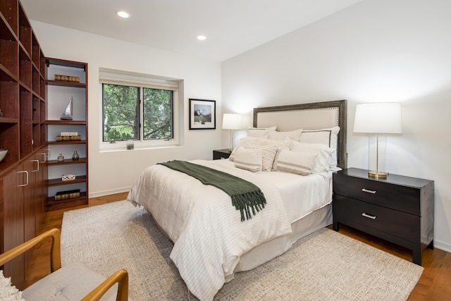 bedroom with recessed lighting, wood finished floors, and baseboards