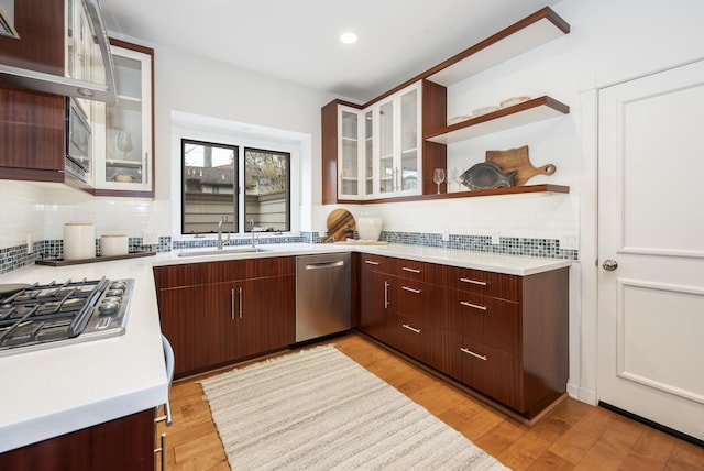 kitchen featuring backsplash, light countertops, dishwasher, and a sink