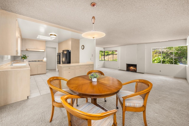 dining space featuring a textured ceiling, a brick fireplace, light tile patterned floors, and light carpet