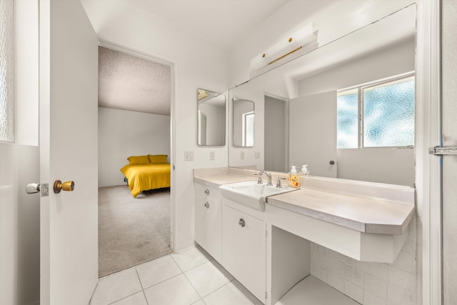 bathroom with connected bathroom, tile patterned flooring, and vanity