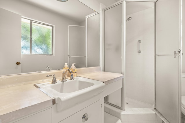 bathroom with vanity, a shower stall, and toilet