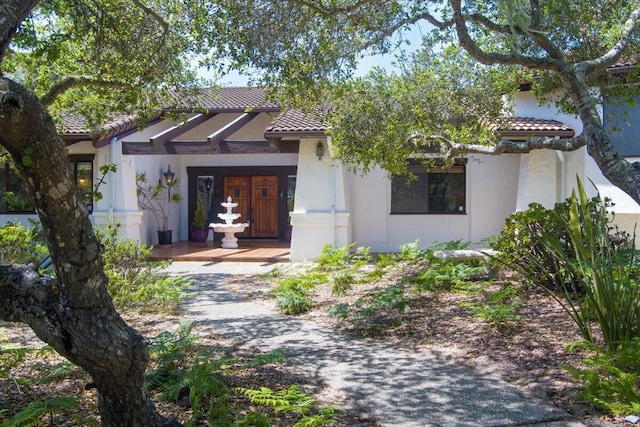 view of front of home with a tiled roof and stucco siding