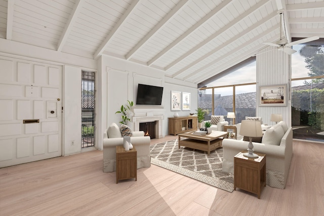 living area featuring high vaulted ceiling, beam ceiling, light wood-style flooring, and a warm lit fireplace