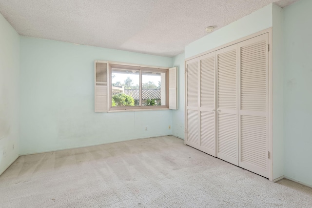 unfurnished bedroom featuring a closet, carpet flooring, and a textured ceiling