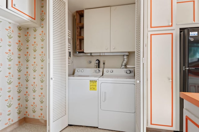 laundry area featuring baseboards, wallpapered walls, cabinet space, and washing machine and clothes dryer