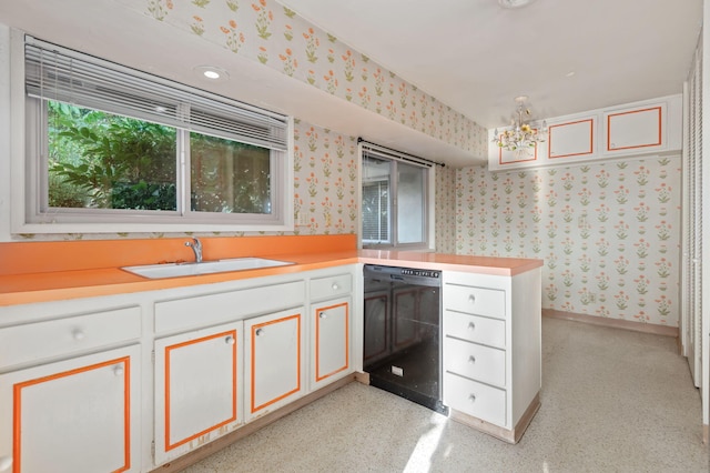 kitchen featuring white cabinets, a sink, light countertops, wallpapered walls, and dishwasher