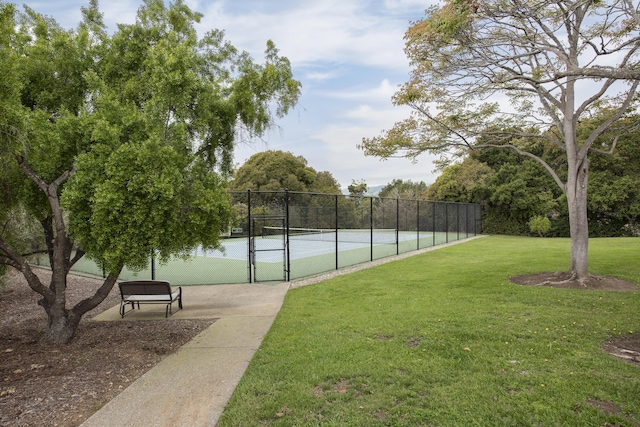 view of sport court with a gate, fence, and a yard