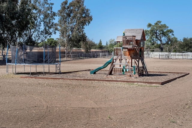 community play area featuring a trampoline and fence