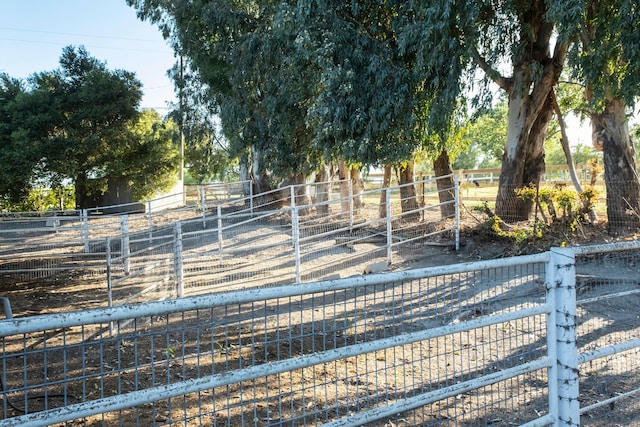 view of yard featuring a rural view, an outdoor structure, and an exterior structure