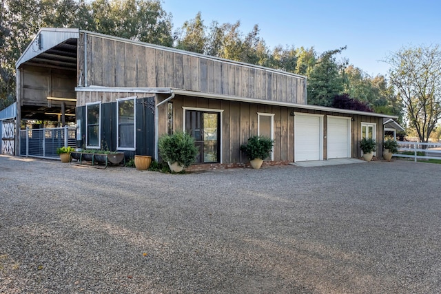 view of front of property with fence and a detached garage