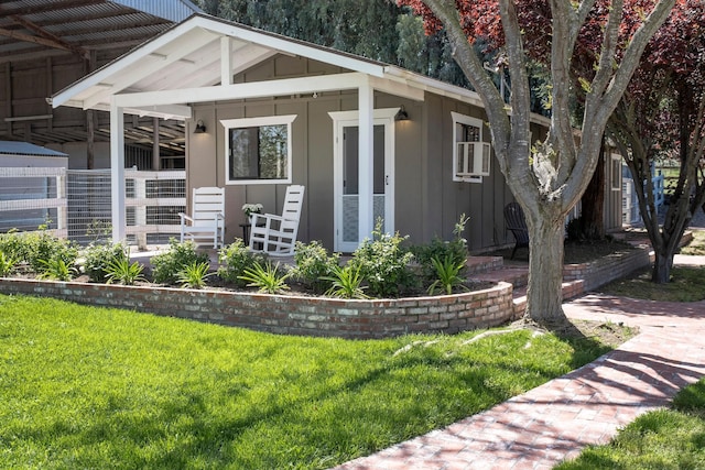 exterior space with board and batten siding, a porch, and a yard