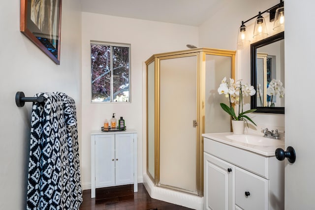 full bathroom featuring wood finished floors, vanity, and a shower stall