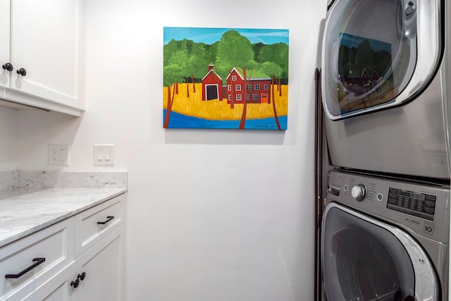 clothes washing area featuring cabinet space and stacked washer / drying machine