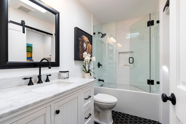 full bath featuring visible vents, toilet, shower / bath combination with glass door, and vanity
