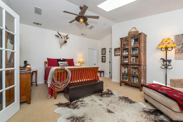 bedroom with visible vents, light carpet, and lofted ceiling with skylight
