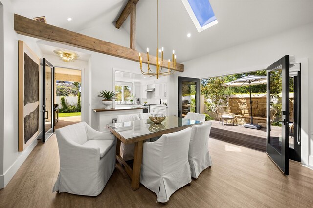 dining room featuring a chandelier, beam ceiling, light wood-type flooring, recessed lighting, and a skylight