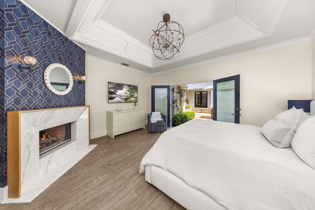 bedroom featuring an inviting chandelier, an accent wall, ornamental molding, a high end fireplace, and visible vents