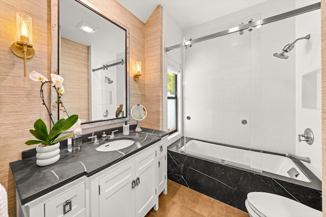 full bathroom with shower / bath combination with glass door, toilet, tile patterned flooring, and vanity
