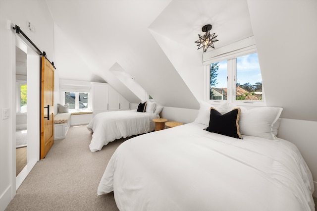 bedroom with lofted ceiling, a barn door, light carpet, and multiple windows