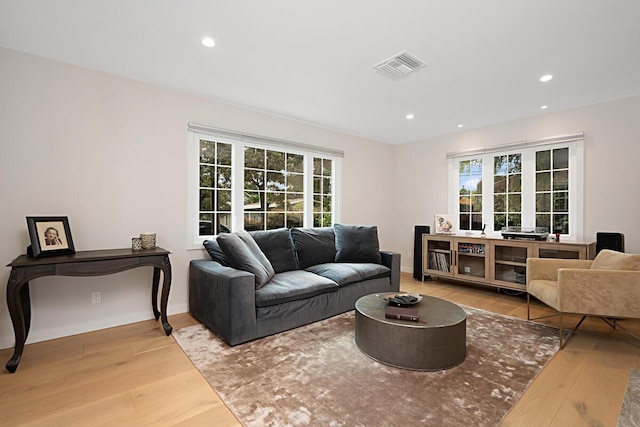 living area featuring visible vents, recessed lighting, baseboards, and wood finished floors