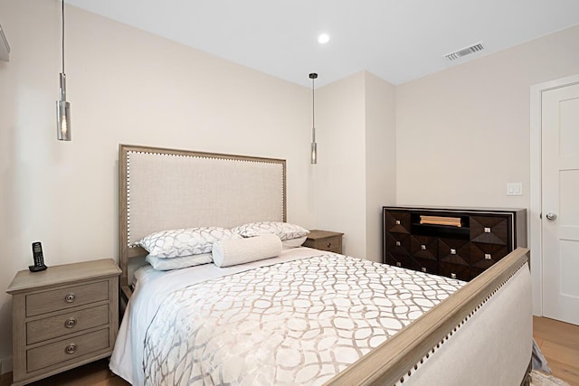 bedroom with recessed lighting, wood finished floors, and visible vents