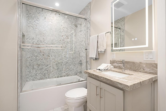 bathroom featuring toilet, combined bath / shower with glass door, and vanity