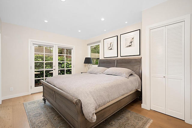 bedroom with access to outside, light wood finished floors, multiple windows, and french doors