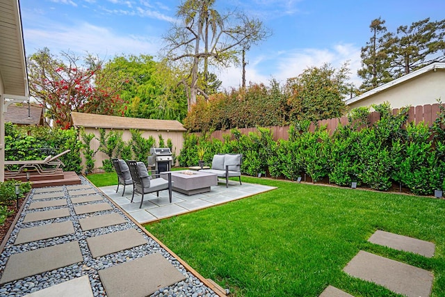 view of yard featuring a fenced backyard, an outdoor living space with a fire pit, and a patio area