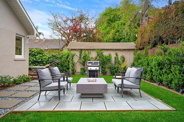 view of patio / terrace with grilling area, fence, and an outdoor living space with a fire pit