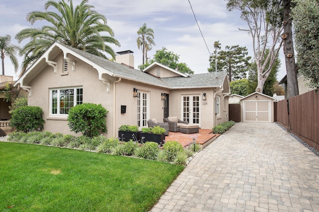 228 W Mission St, Santa Barbara, CA 93101 - view of front of home featuring an outdoor hangout area, french doors, stucco siding, a storage shed, and decorative driveway