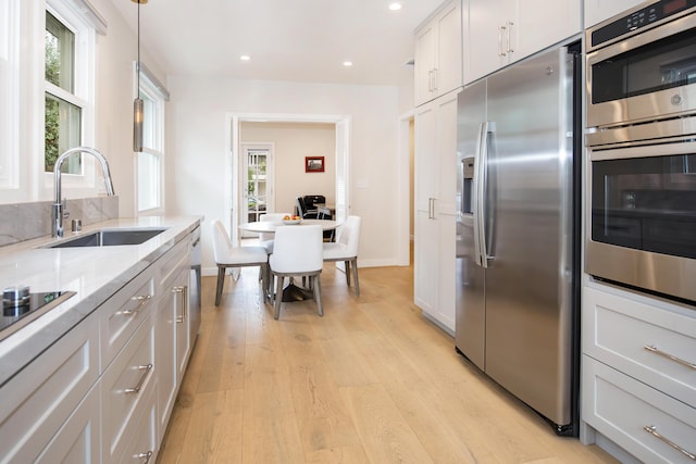 228 W Mission St, Santa Barbara, CA 93101 - kitchen featuring appliances with stainless steel finishes, light wood-style floors, plenty of natural light, light stone countertops, and recessed lighting